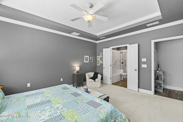 carpeted bedroom featuring baseboards, visible vents, ornamental molding, a textured ceiling, and a raised ceiling