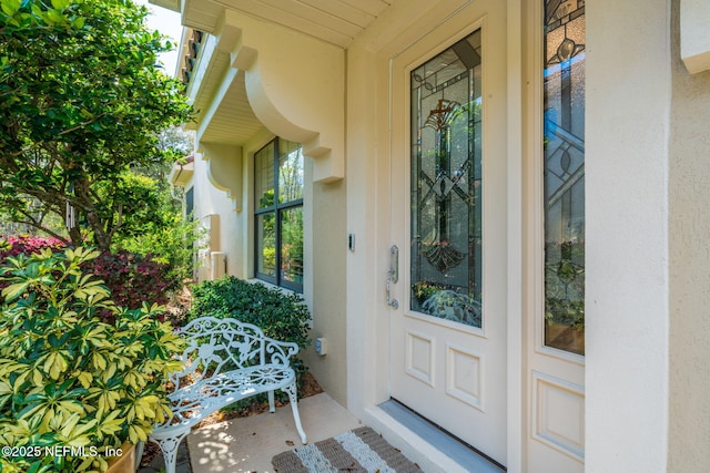 entrance to property featuring stucco siding