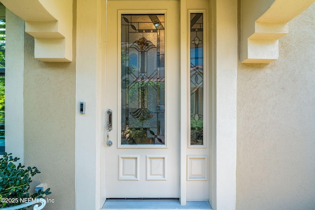 property entrance featuring stucco siding