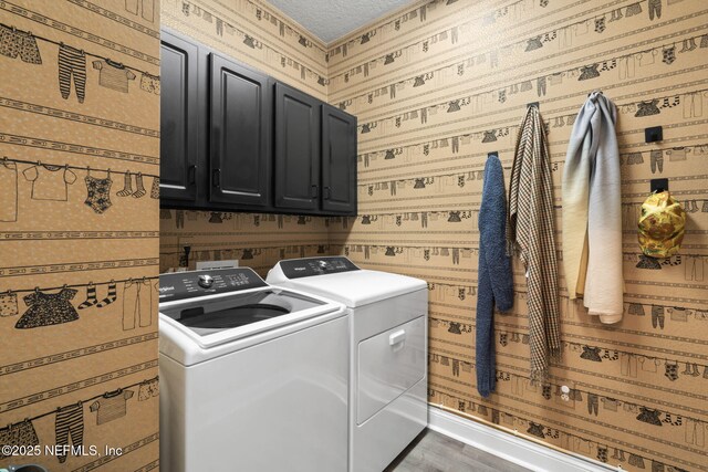 clothes washing area with wallpapered walls, baseboards, wood finished floors, cabinet space, and separate washer and dryer