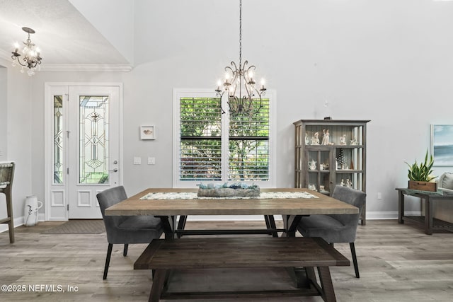 dining room featuring a notable chandelier, baseboards, and light wood-style floors