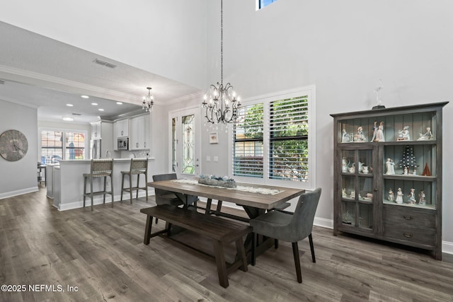 dining room featuring visible vents, baseboards, dark wood finished floors, and crown molding