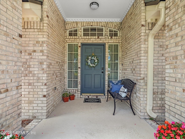 doorway to property featuring brick siding