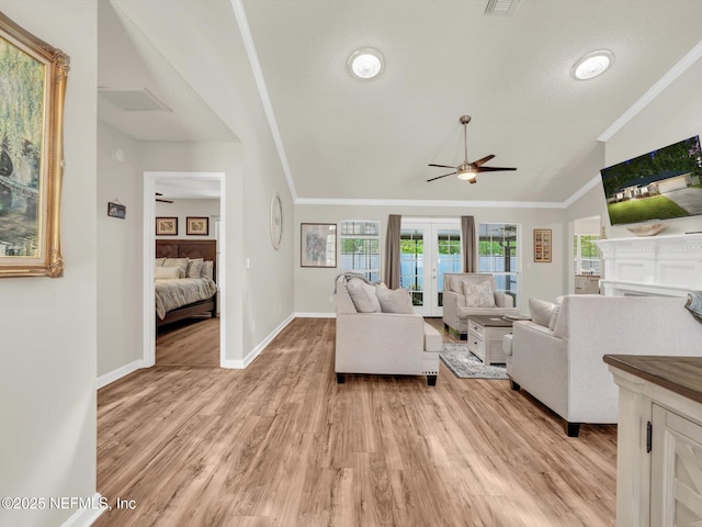 living area with light wood-type flooring, vaulted ceiling, crown molding, and french doors