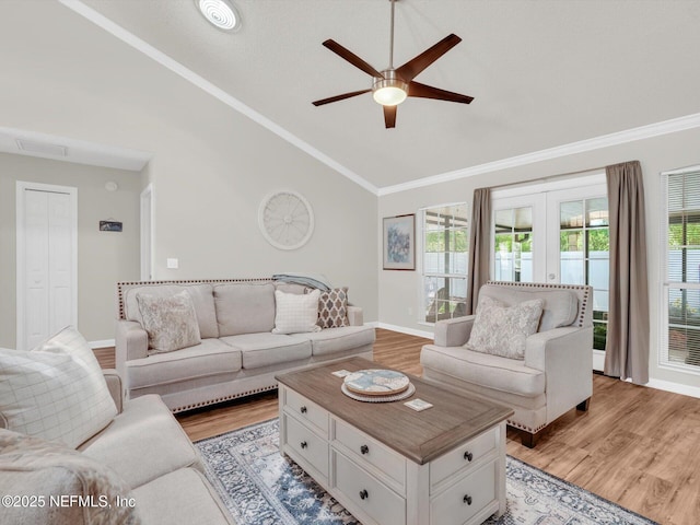 living area featuring light wood-style flooring, visible vents, a ceiling fan, french doors, and crown molding