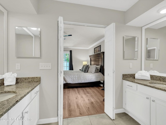 bedroom with a sink, baseboards, and light tile patterned floors