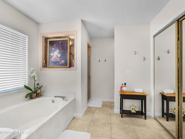 full bathroom featuring a textured ceiling, baseboards, a shower stall, a bath, and tile patterned floors