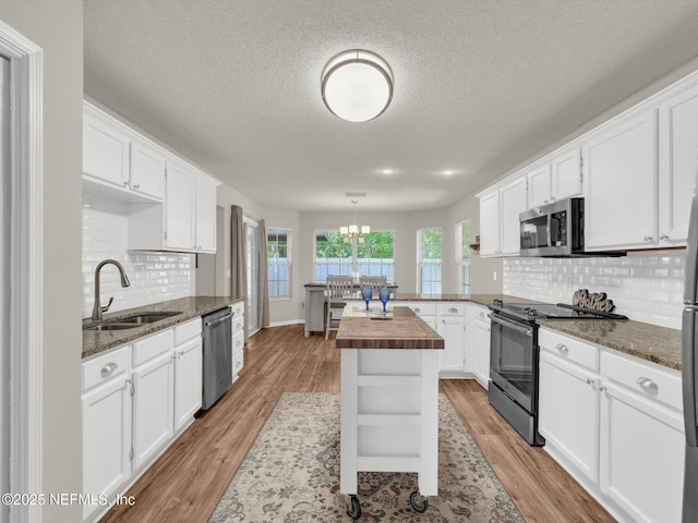 kitchen with light wood-style floors, butcher block counters, stainless steel appliances, and a sink