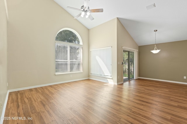 spare room featuring high vaulted ceiling, visible vents, plenty of natural light, and wood finished floors