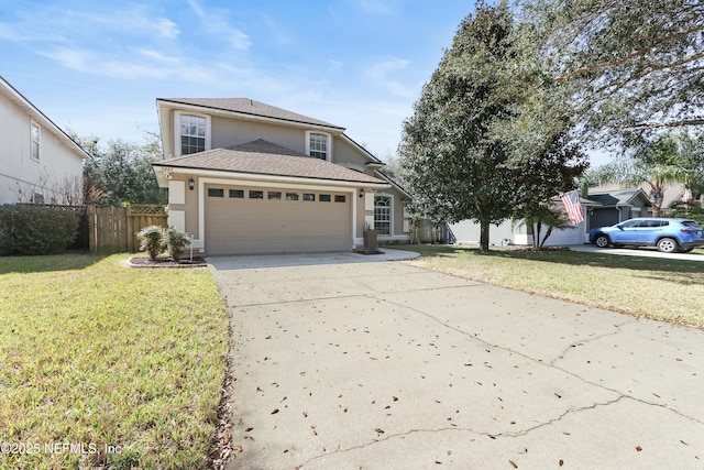 traditional-style house with an attached garage, fence, concrete driveway, stucco siding, and a front lawn