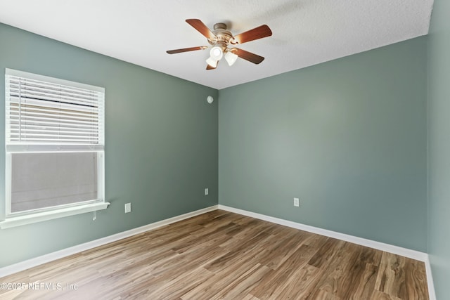 unfurnished room featuring a ceiling fan, a textured ceiling, baseboards, and wood finished floors