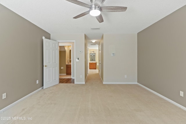 unfurnished bedroom featuring visible vents, light carpet, ensuite bath, and baseboards