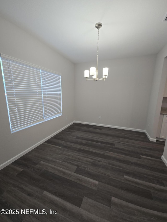 unfurnished room with dark wood-style floors, visible vents, baseboards, and an inviting chandelier