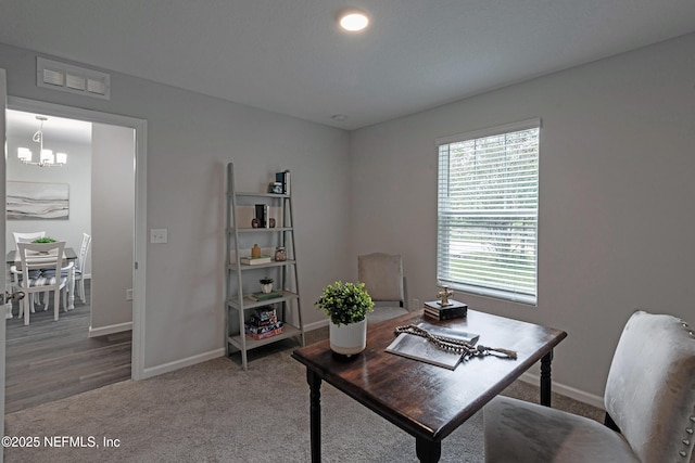 home office with an inviting chandelier, baseboards, visible vents, and carpet flooring