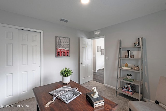 office featuring carpet flooring, visible vents, and baseboards