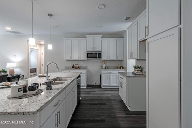 kitchen with visible vents, appliances with stainless steel finishes, dark wood-type flooring, a textured ceiling, and a sink