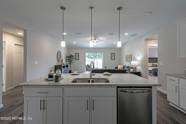 kitchen with dishwasher, open floor plan, dark wood-type flooring, decorative light fixtures, and a sink