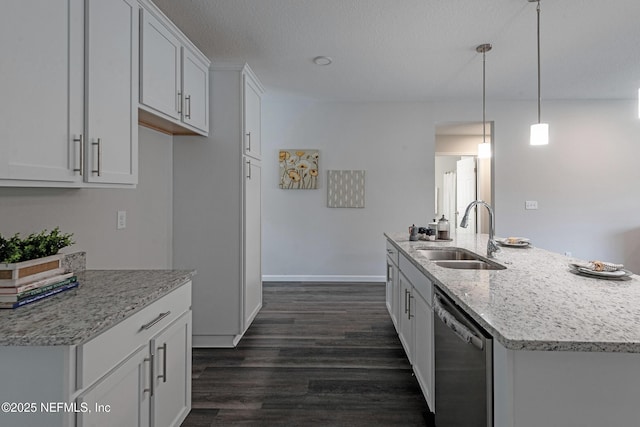 kitchen with light stone counters, dark wood-type flooring, a sink, white cabinets, and dishwasher