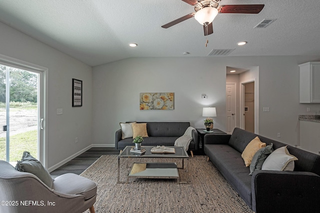 living area with lofted ceiling, baseboards, visible vents, and dark wood finished floors