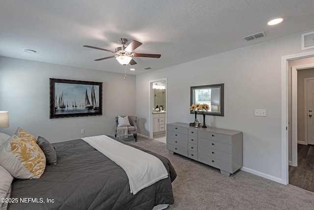 bedroom with a textured ceiling, carpet flooring, visible vents, and baseboards