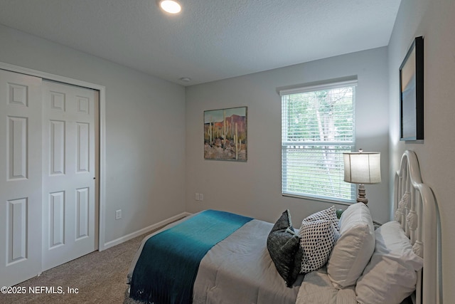 bedroom with carpet floors, a textured ceiling, and baseboards