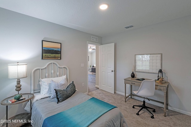 carpeted bedroom featuring baseboards, visible vents, and a textured ceiling