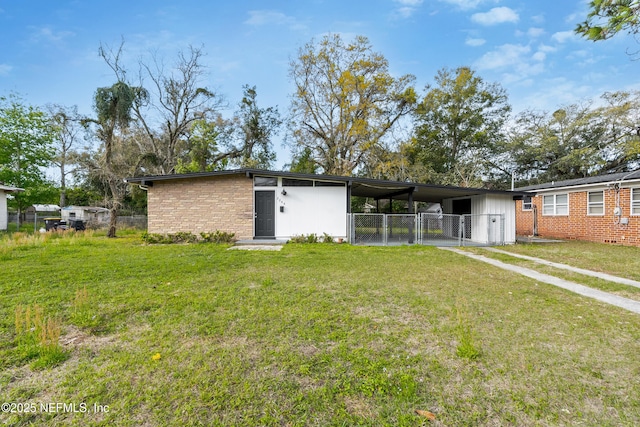 back of house featuring fence, an attached carport, and a yard