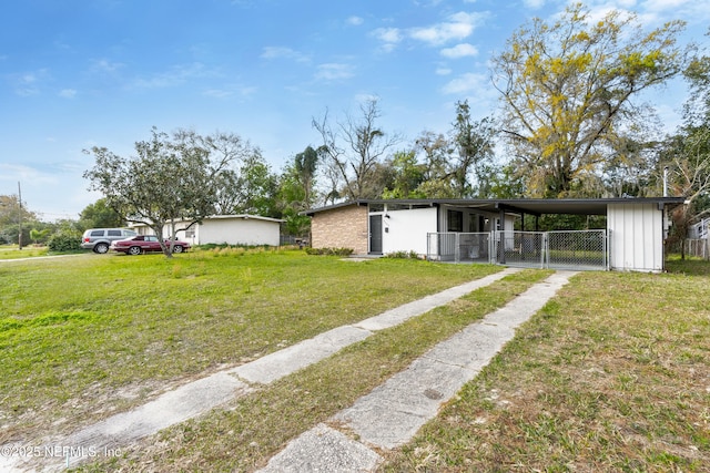 mid-century modern home with a front yard, driveway, an attached carport, and fence