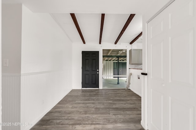 entryway featuring a wainscoted wall, wood finished floors, and beam ceiling