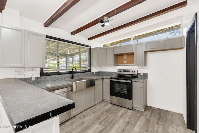 kitchen with decorative backsplash, appliances with stainless steel finishes, gray cabinetry, light wood-style floors, and a sink