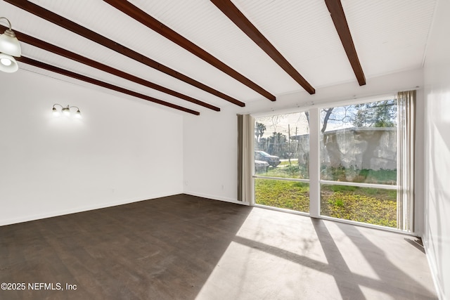 unfurnished living room featuring beamed ceiling and baseboards