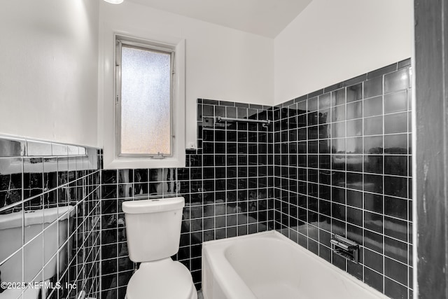 bathroom featuring toilet and tile walls