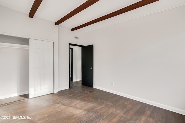 unfurnished bedroom featuring dark wood-type flooring, visible vents, baseboards, a closet, and beam ceiling