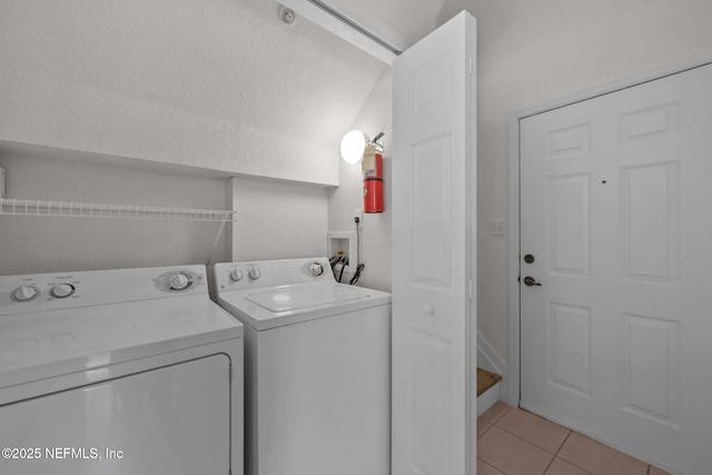 washroom featuring washer and clothes dryer and light tile patterned flooring