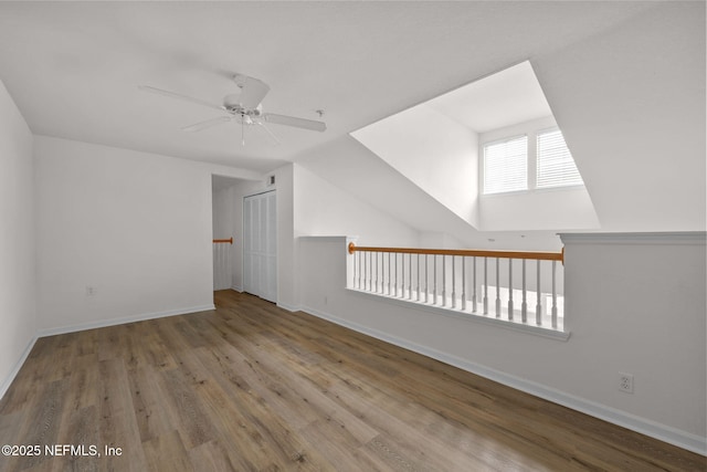 additional living space featuring ceiling fan, baseboards, and wood finished floors