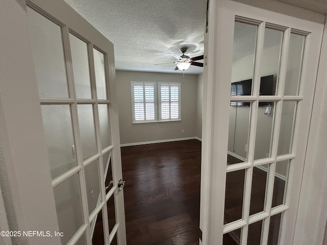 spare room featuring ceiling fan, baseboards, a textured ceiling, and wood finished floors