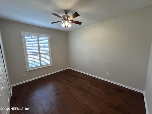 unfurnished room with baseboards, a ceiling fan, dark wood-style flooring, and a textured ceiling