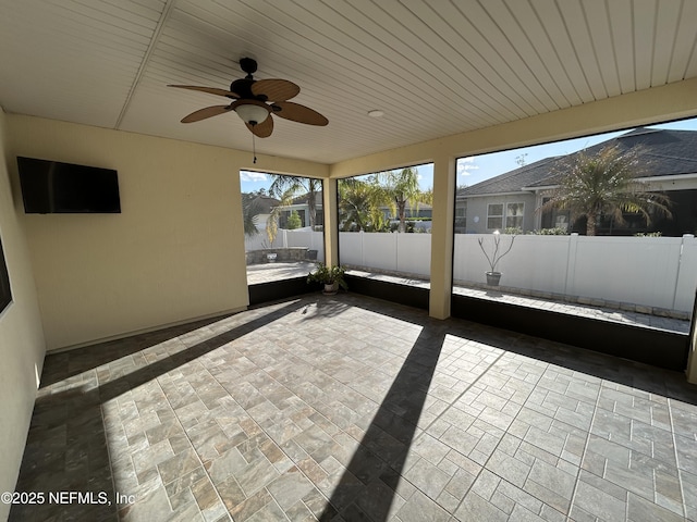 unfurnished sunroom with ceiling fan