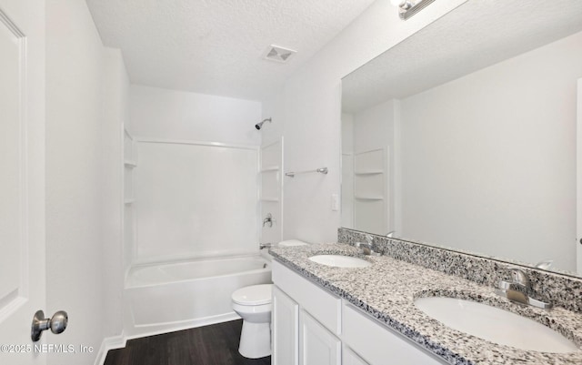 bathroom with visible vents, a sink, a textured ceiling, and toilet