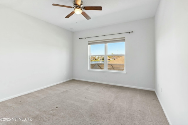 empty room featuring ceiling fan, baseboards, and carpet flooring