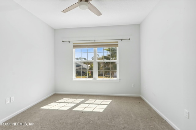 carpeted empty room with ceiling fan and baseboards