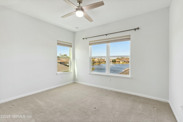 unfurnished room with a ceiling fan, carpet flooring, and baseboards