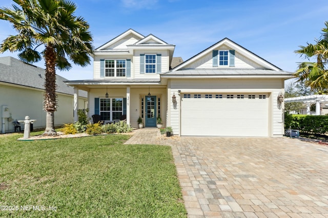 view of front of home with decorative driveway, an attached garage, a standing seam roof, metal roof, and a front lawn