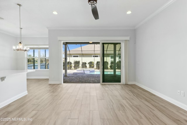 empty room featuring ornamental molding, wood finished floors, and baseboards