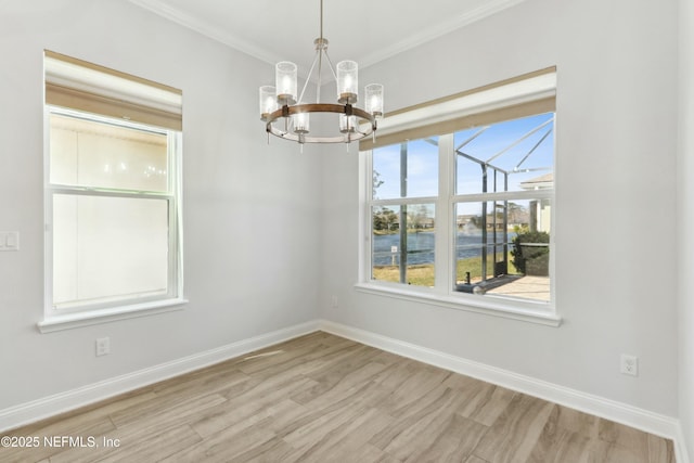 unfurnished dining area featuring a chandelier, ornamental molding, wood finished floors, and baseboards