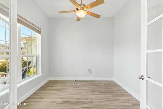 unfurnished room with light wood-style flooring, baseboards, a ceiling fan, and french doors