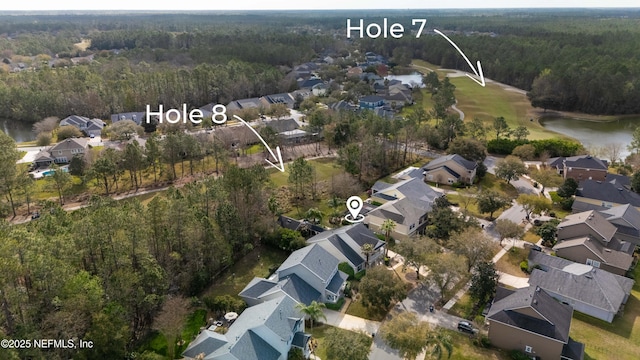 drone / aerial view featuring a water view, a forest view, and a residential view