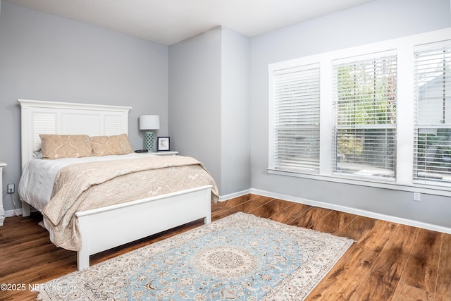 bedroom featuring wood finished floors and baseboards