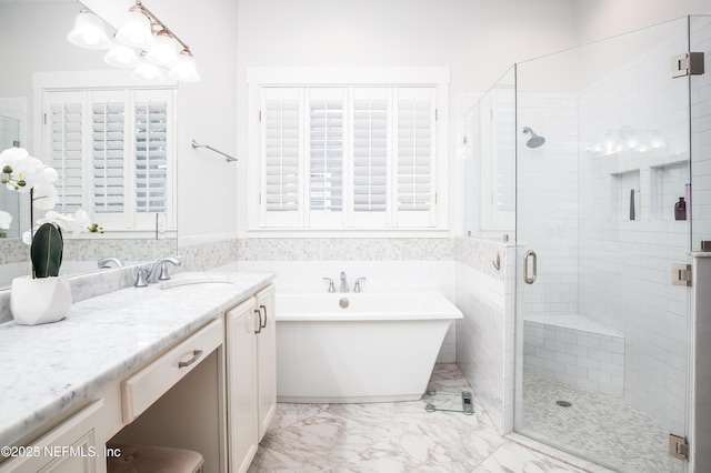 bathroom with a stall shower, a soaking tub, vanity, and marble finish floor