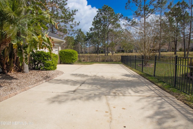 view of patio featuring fence and concrete driveway